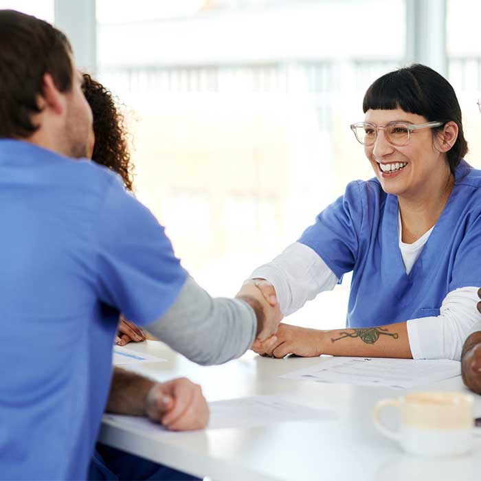 Two nurses shaking hands