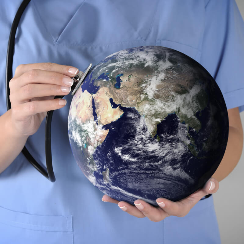 female healthcare professional holding globe and stethoscope