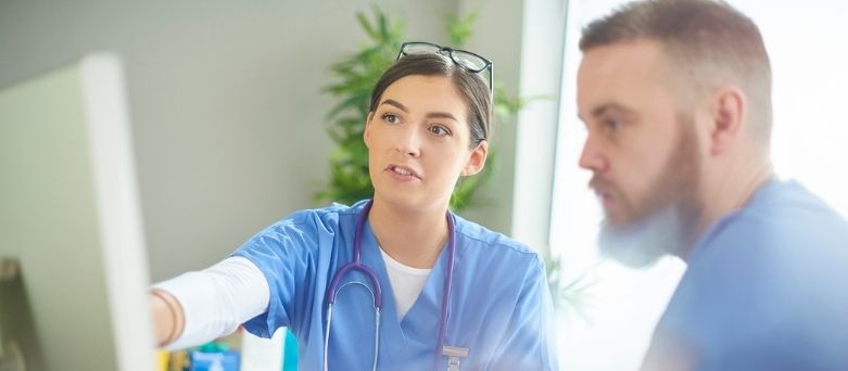 male and female doctors looking at computer