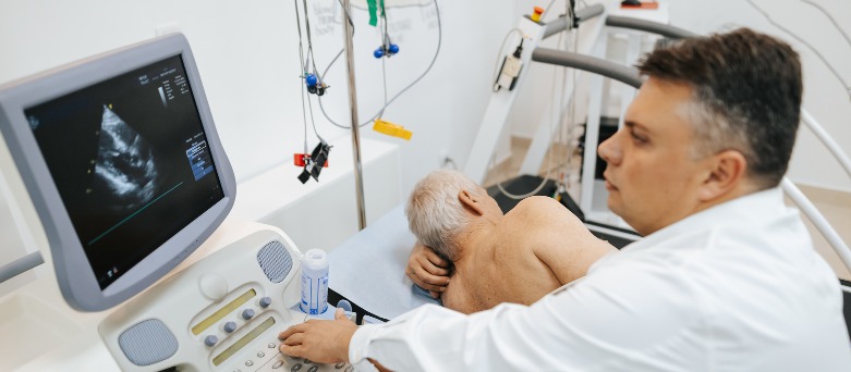 Male cardiologist examining a patients chest with a stethoscope