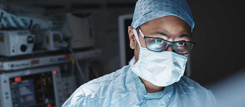 Male Surgeon dressed in scrubs in operating theatre 