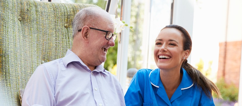 Nurse assisting elderly woman and man in their home