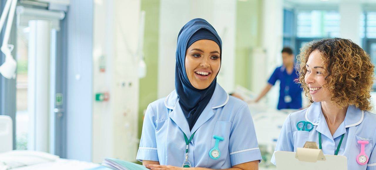 two nurses walking through a ward